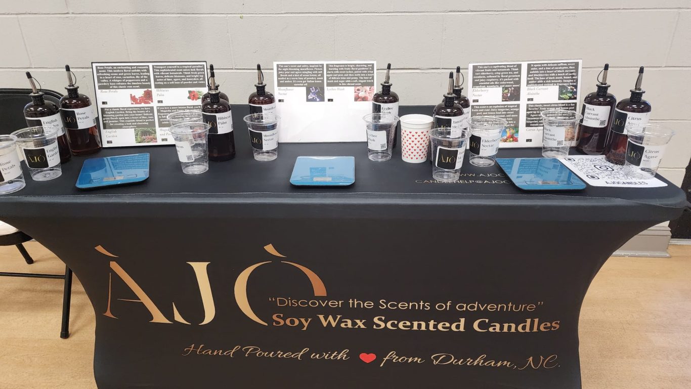 A table displaying various scented candles and promotional materials.